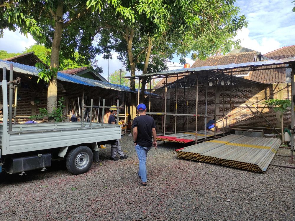 Yard gudang DEO Scaffolding dengan truk armada dan tumpukan material