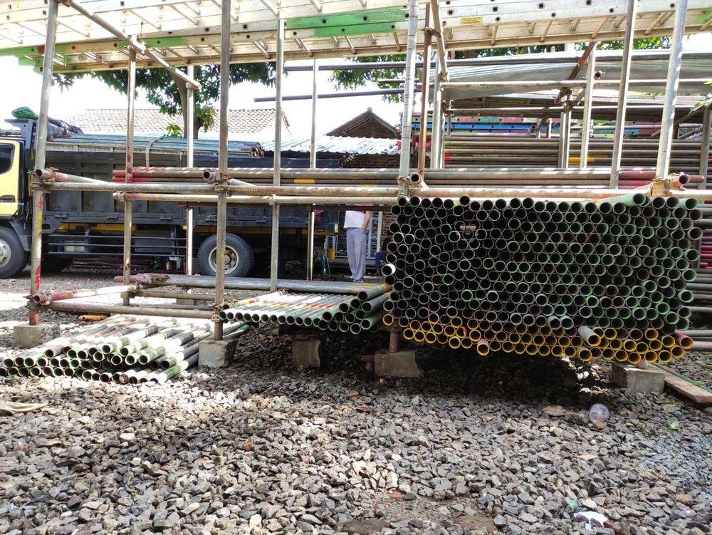 Pipa dan frame scaffolding tertata di rak gudang